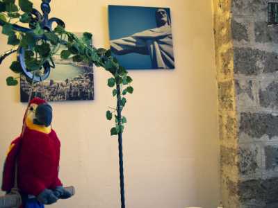 ...mentre alle pareti � affisso un poster del Cristo Redentore, accanto a un variopinto pappagallo di peluche